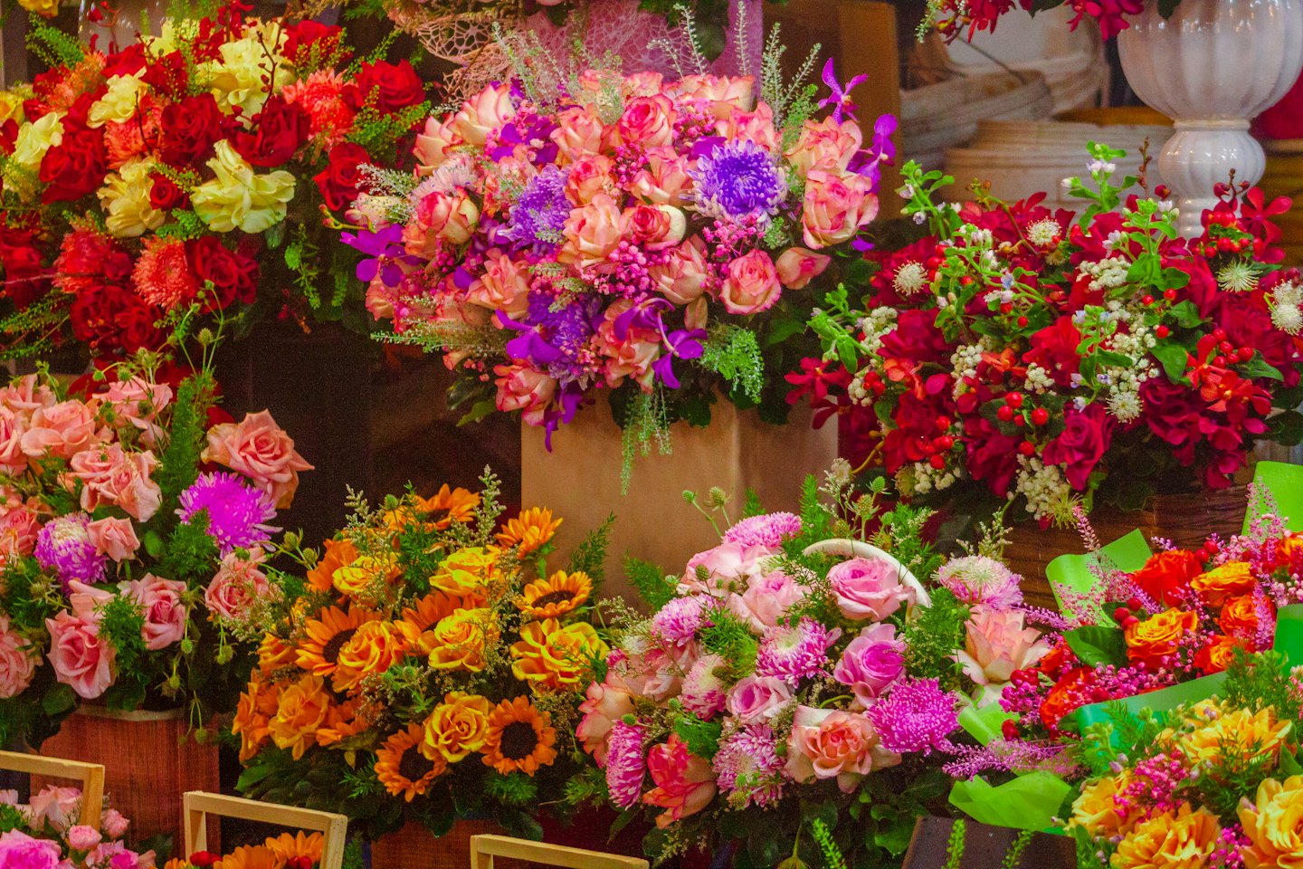 Vari bouquet floreali colorati esposti all'interno di un negozio di fiori.